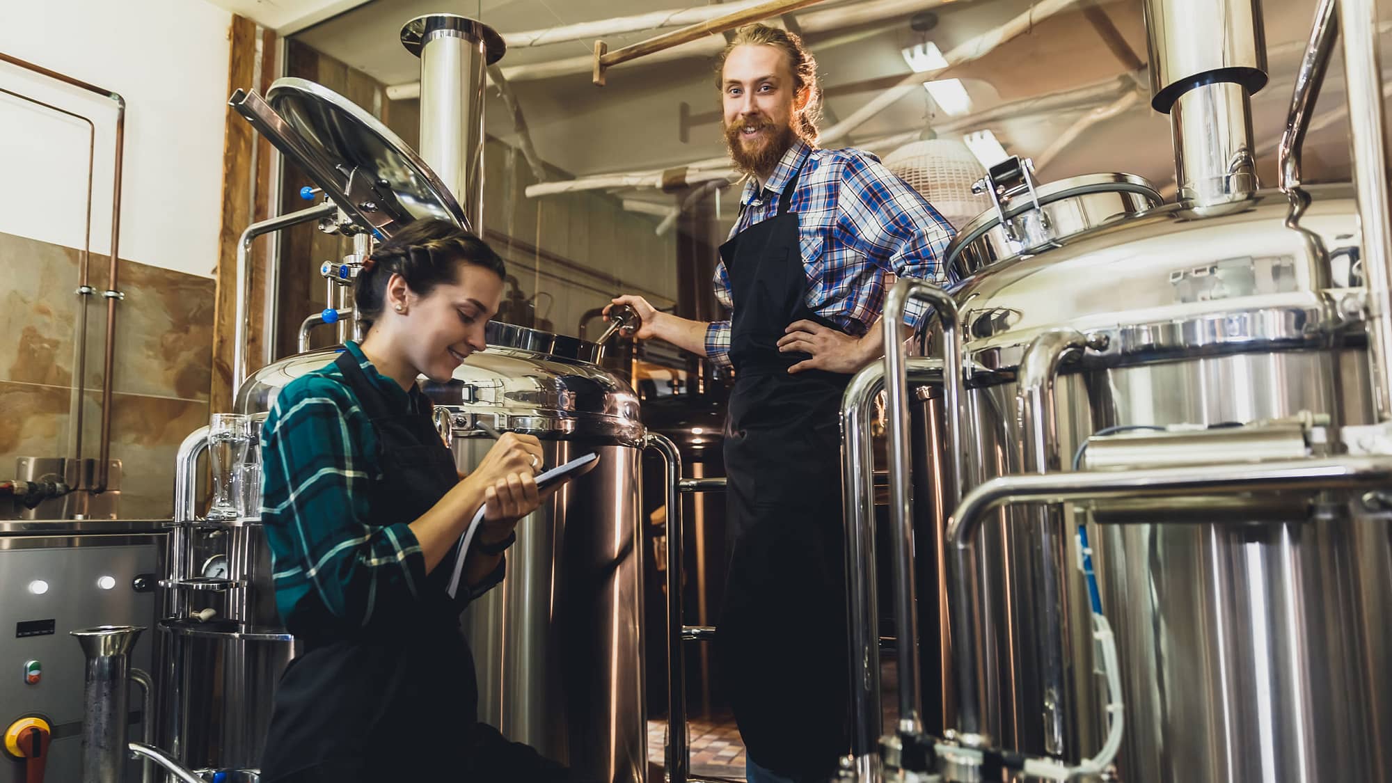 Man and women brewing beer at a brewery.