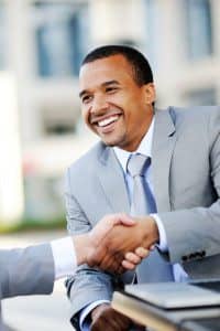 Professional Man Smiles as He Shakes his Business Partner's Hand