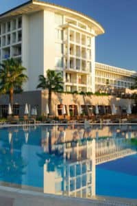 Exterior view of nice hotel with pool in the foreground.