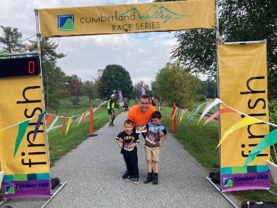 father and sons at finish line of Cumberland Valleys Rails-to-Trails