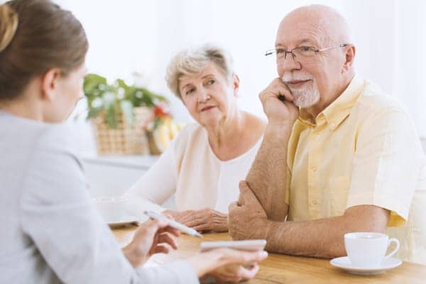 elderly couple discussing life insurance with agent