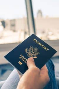 Close up of person's hand holding a passport while at the airport.