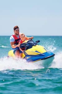 Two couples riding jet skis in the ocean.