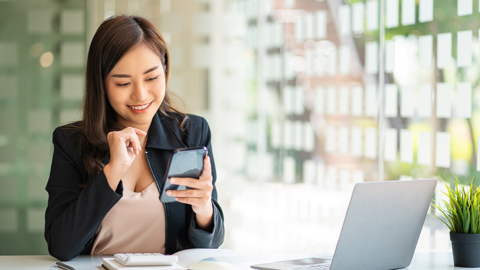 tax credits businesswoman smiling while looking at her phone