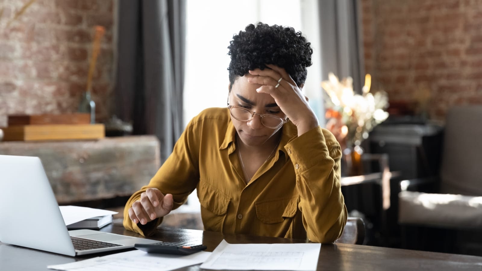 Woman looking at paperwork Woman staring at bills