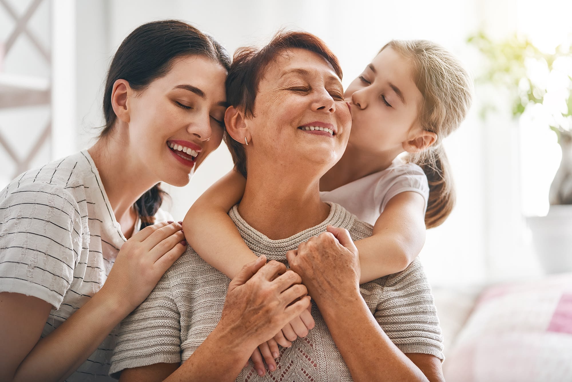 mother grandmother and daughter embracing smiling