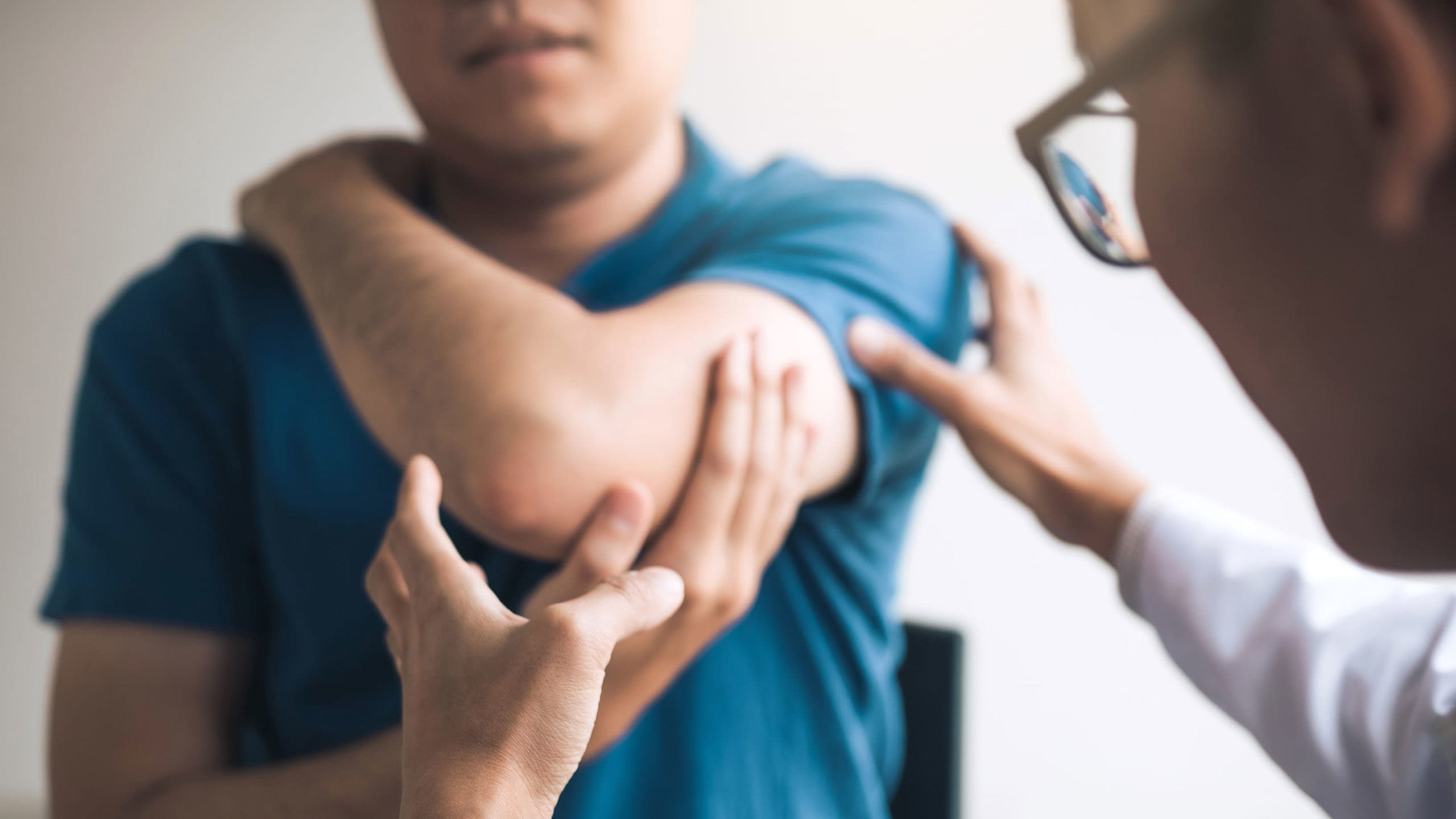 Doctor examining patient's injured elbow.