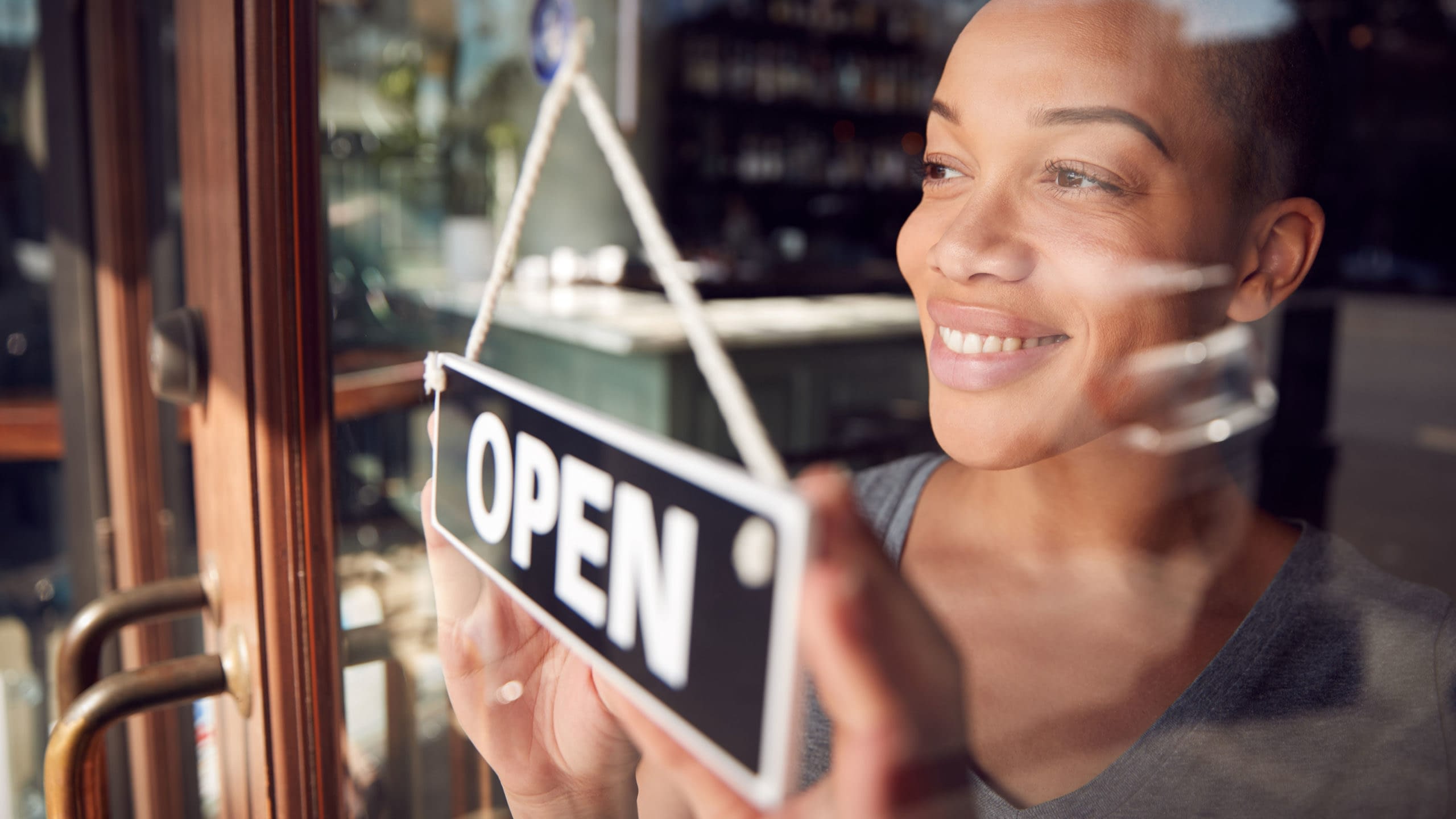 Business owner displaying an OPEN sign on the door.