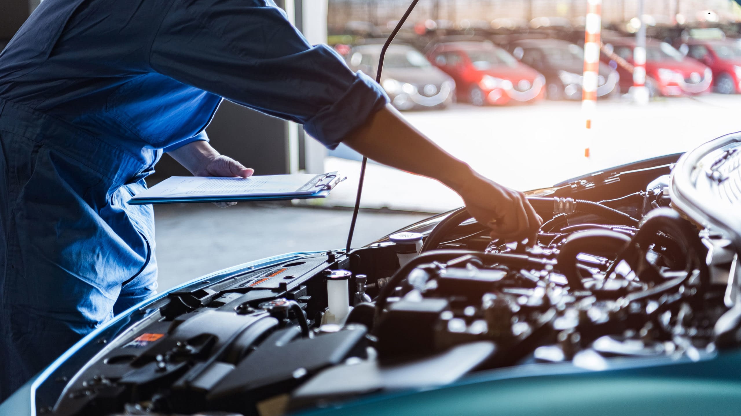 Mechanic working under the hood of an automobile.