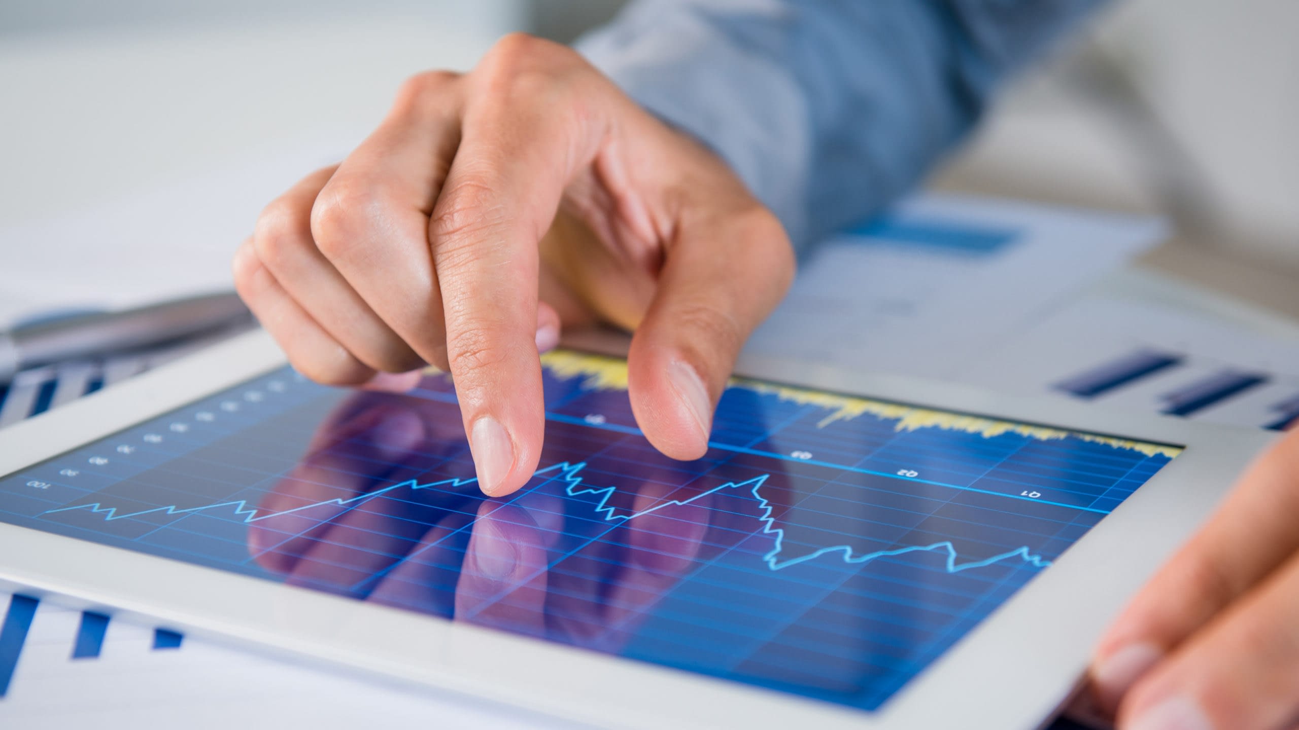 Close up of person using a tablet with a line graph of indexed annuities on the screen.