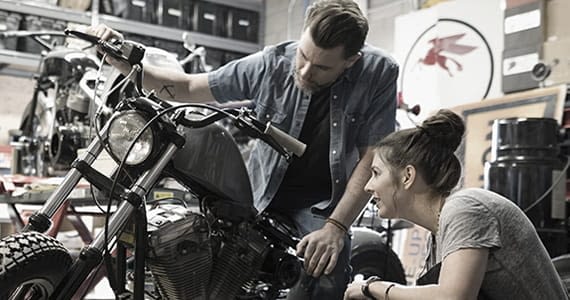 Two people looking at motorcycle