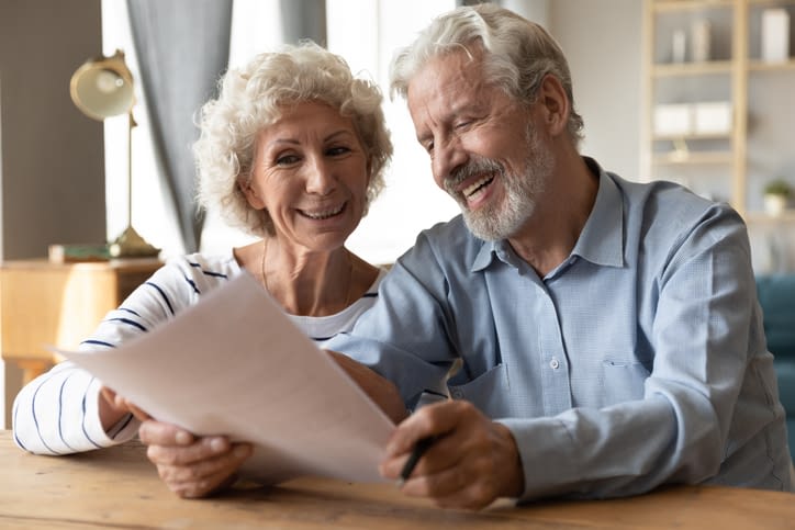Happy mature couple glad with document health insurance contract Happy Senior Couple Reviewing Documents