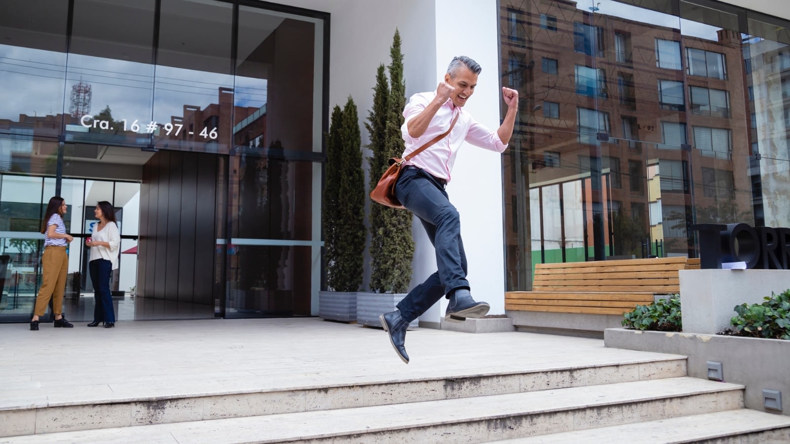 businessman excitedly jumping down stairs outside