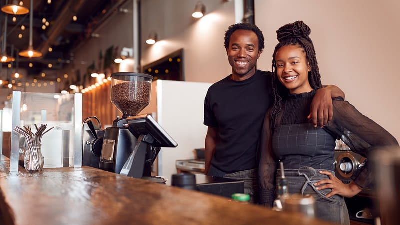 Business owners behind counter of their shop.