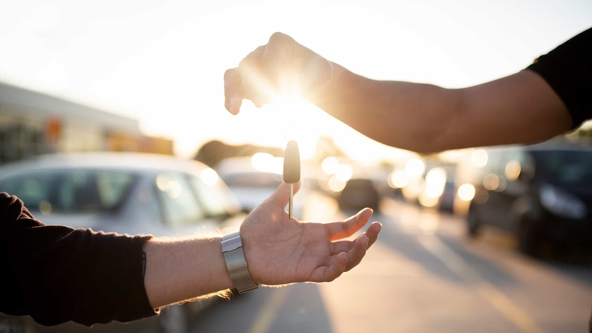 Person handing car keys to another individual.