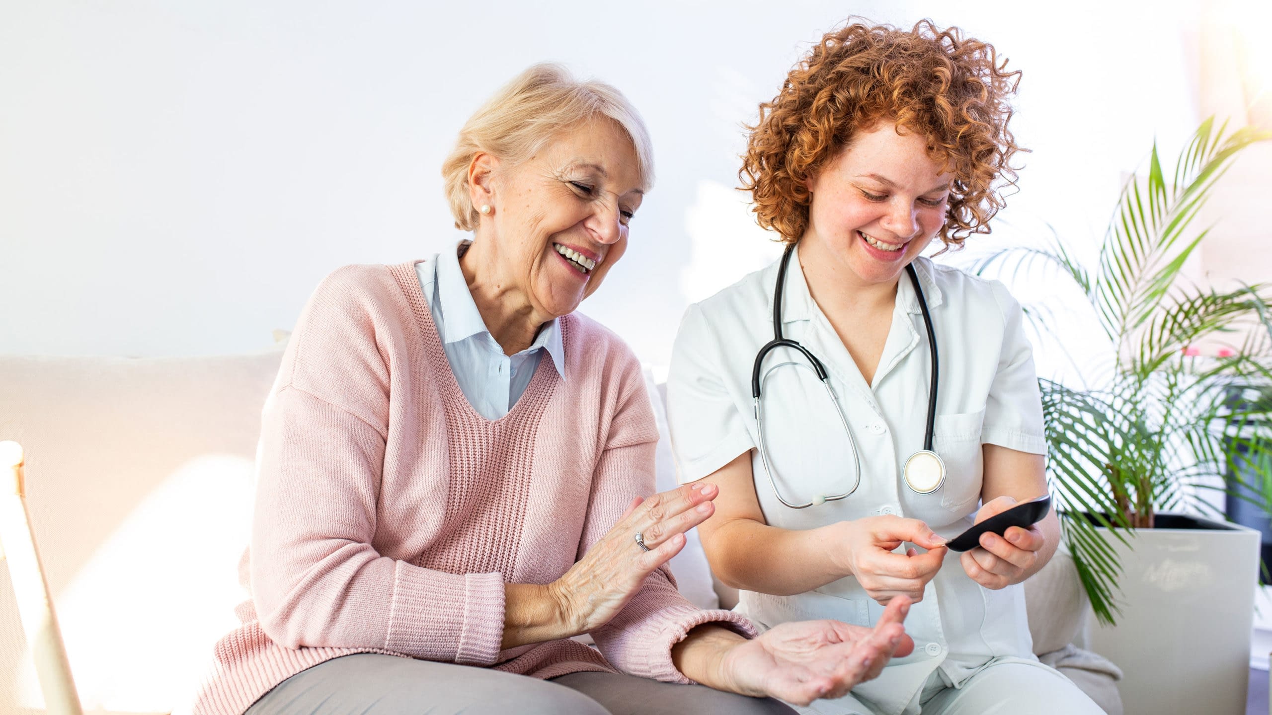 Health care worker measuring a women's blood sugar.