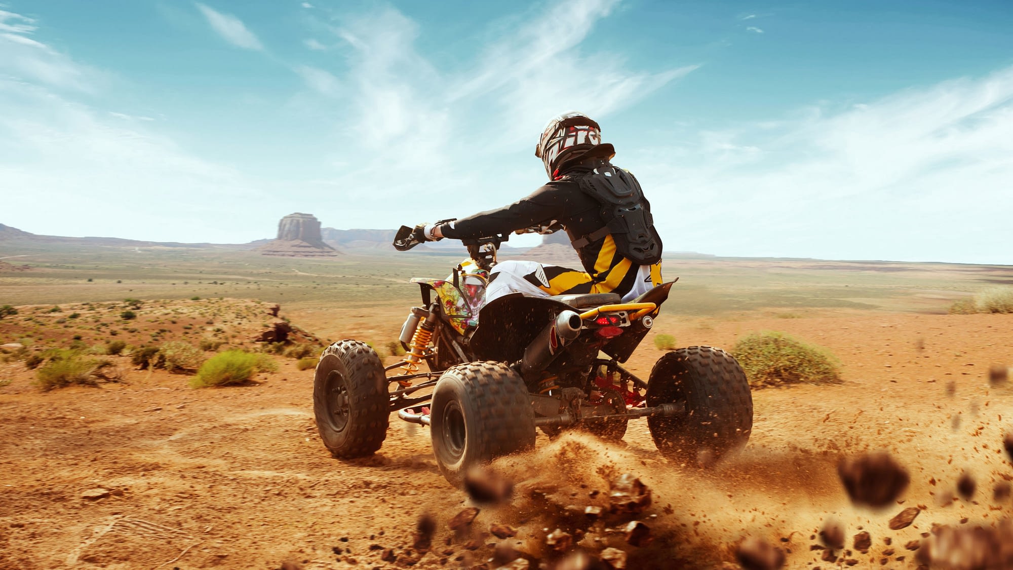 Person riding an ATV in the desert.