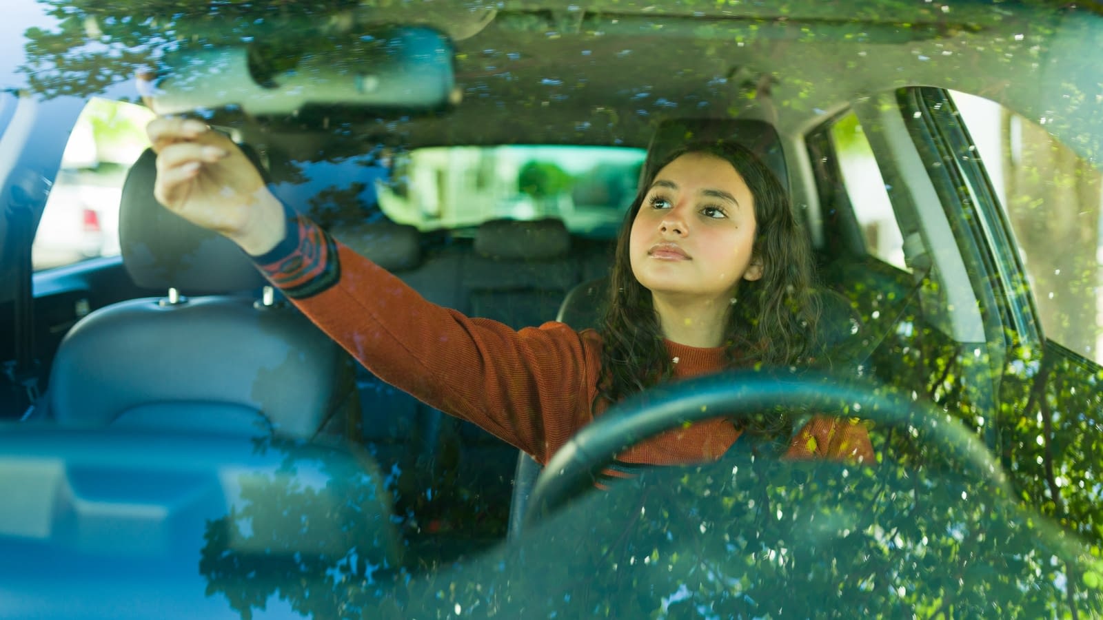 September 2 blog Female teen adjusting rear view mirror in car