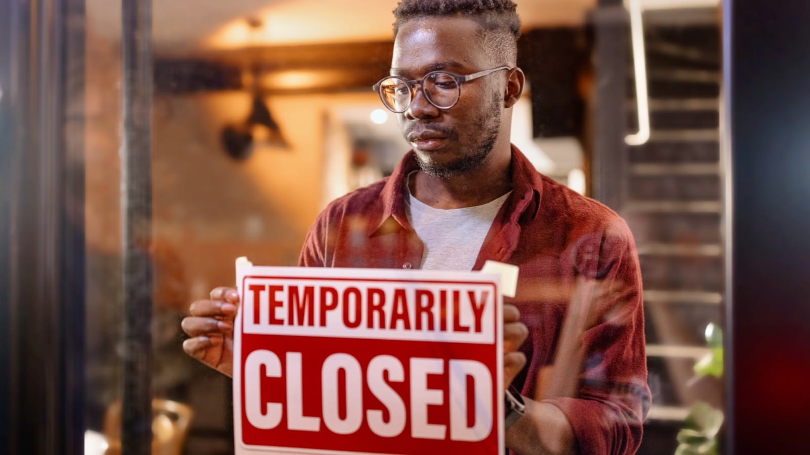 business owner putting up temporarily closed sign