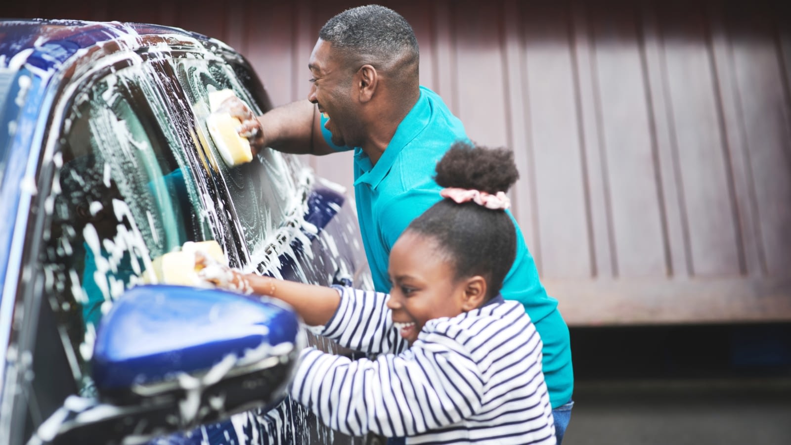 father and daughter washing car