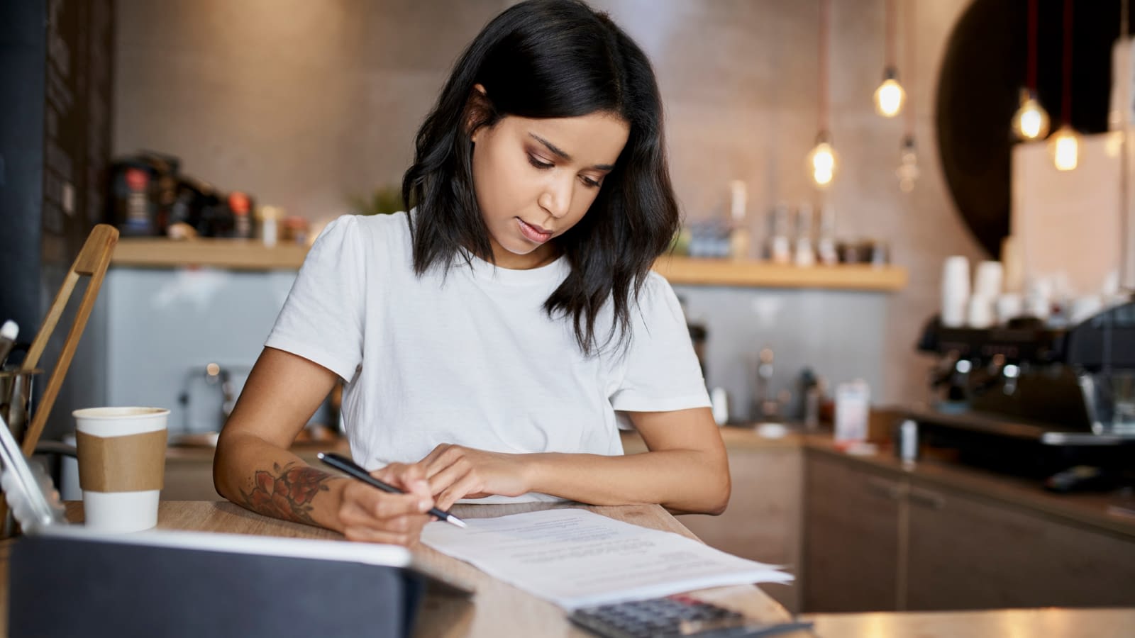 3 A woman in cafe signing papers