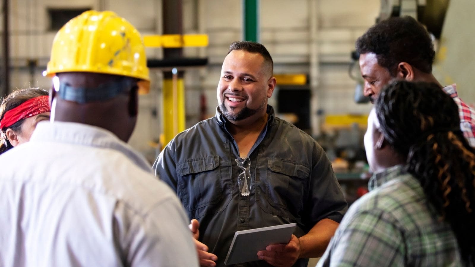 Client Blog August 2025 (1) Multiracial group in factory having a conversation.