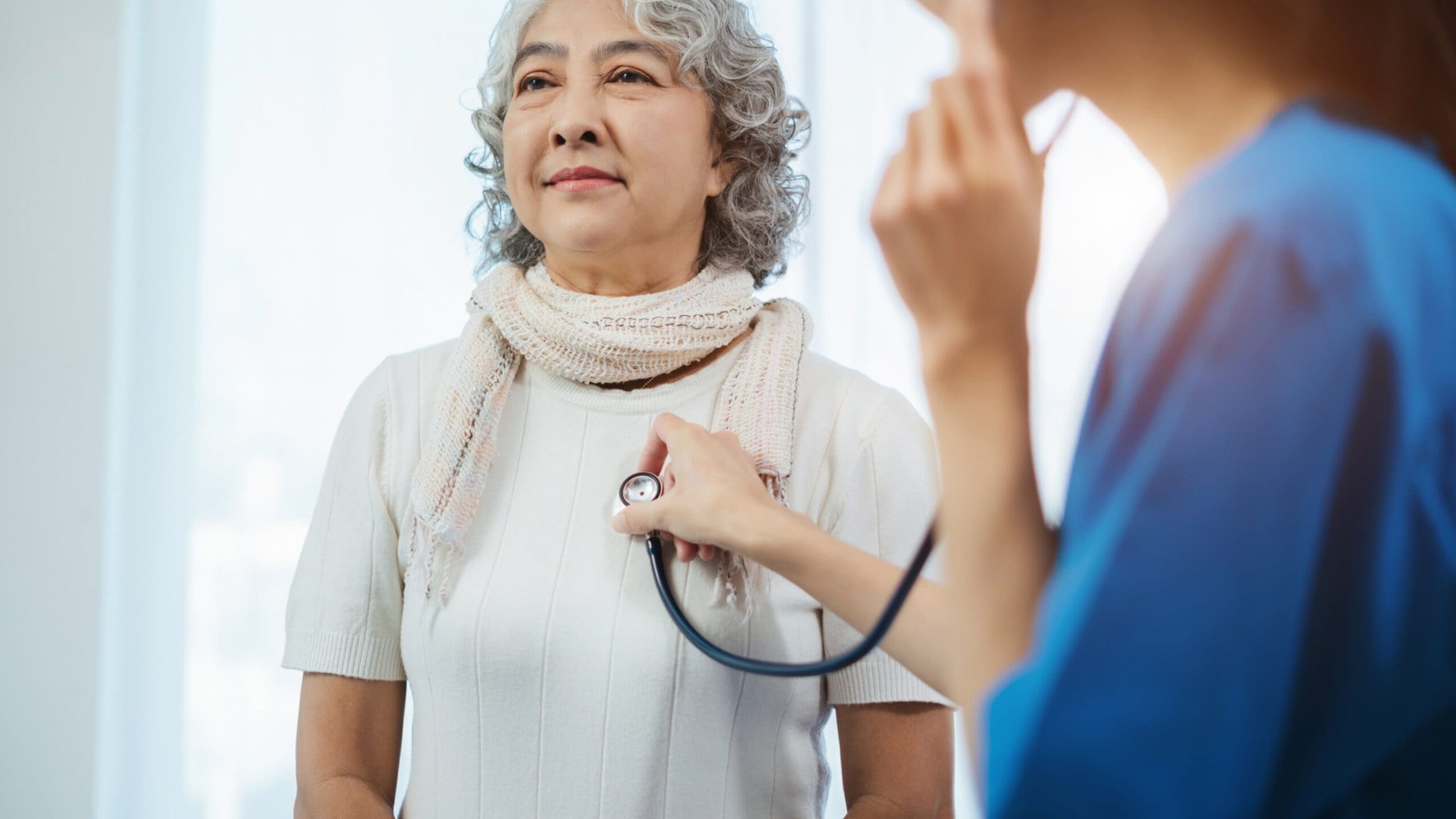 7-21 Blog Image senior woman at doctor appointment with doctor listening to her heart