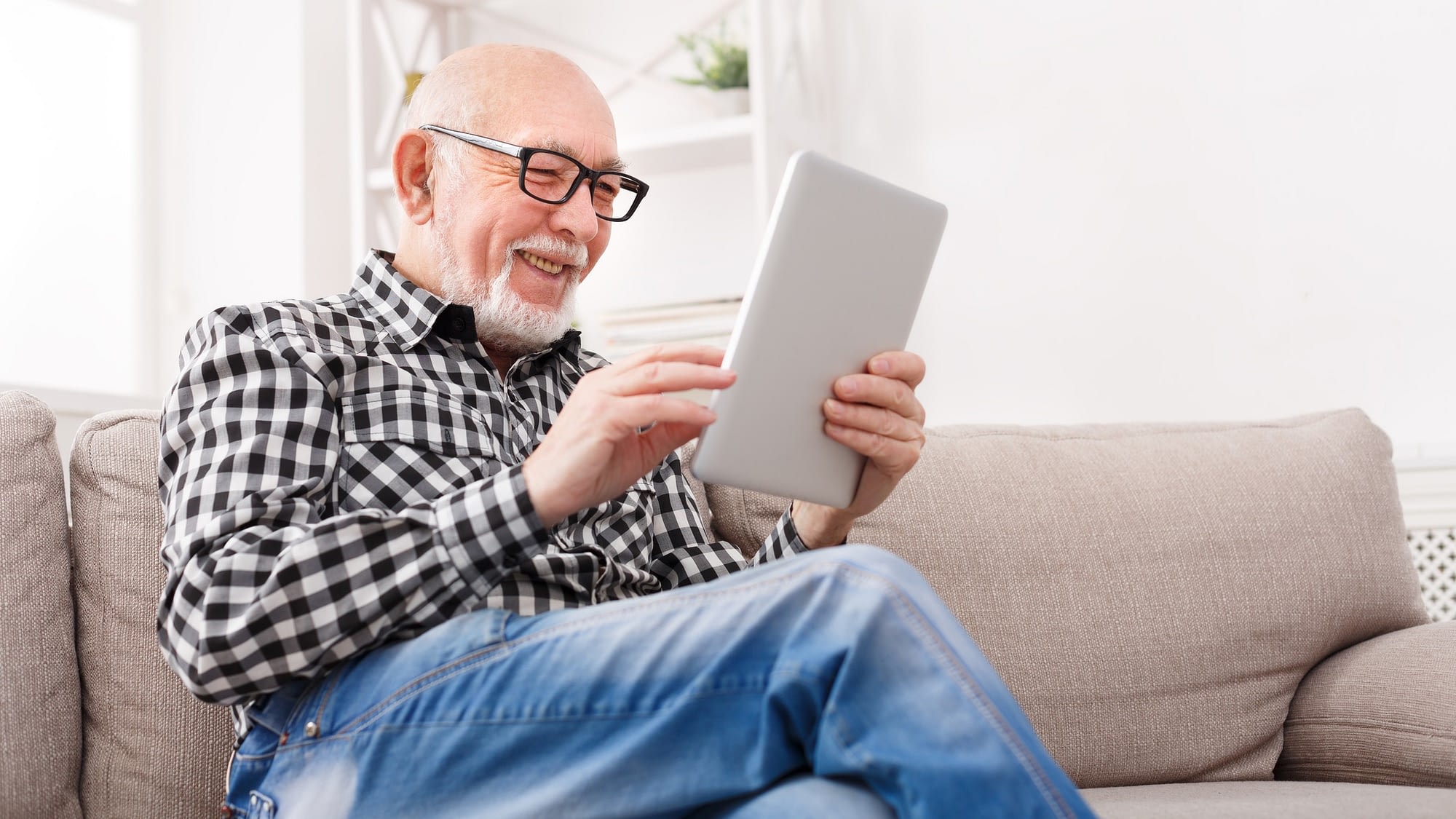 senior man smiling at tablet