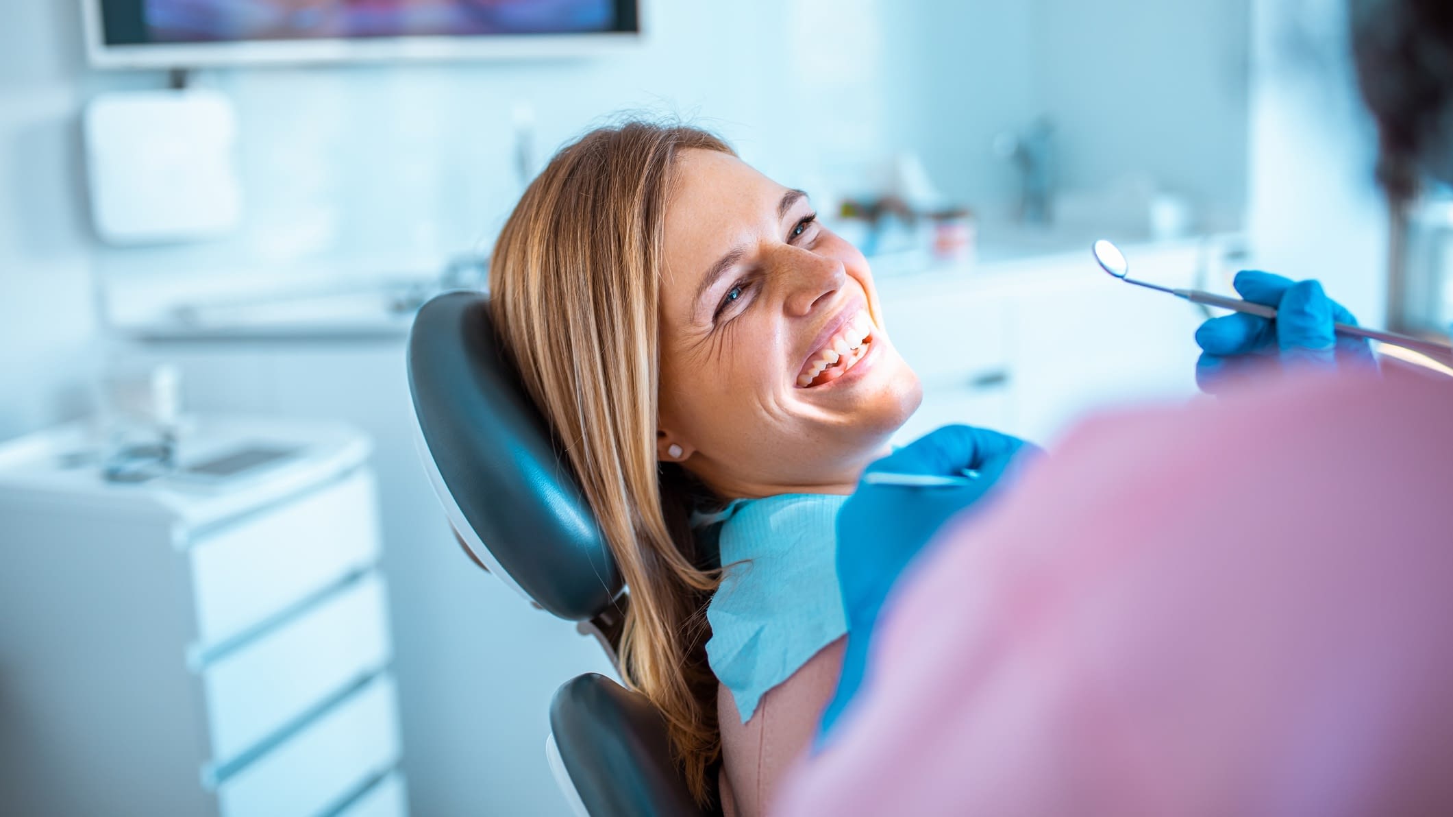 woman getting her teeth cleaned woman in the chair at the dentist
