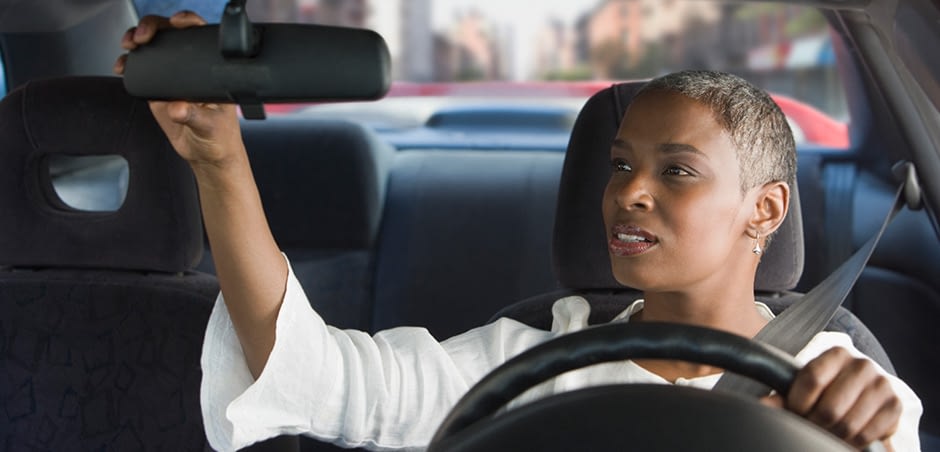 Woman Adjusting Rearview Mirror