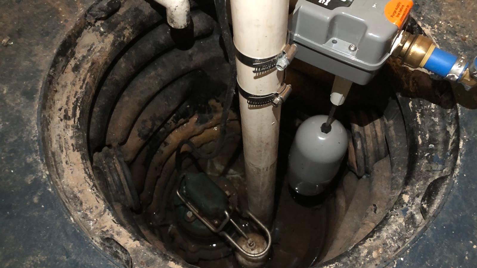 Basement sump pump installation A real sump pump installed inside a basement sump basin.