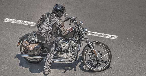 person_getting_onto_their_motorcycle_575x300