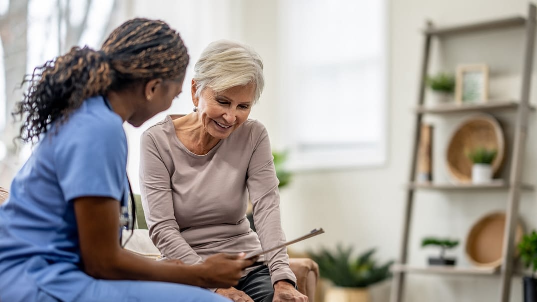 Young doctor speaking with her elderly female patient.