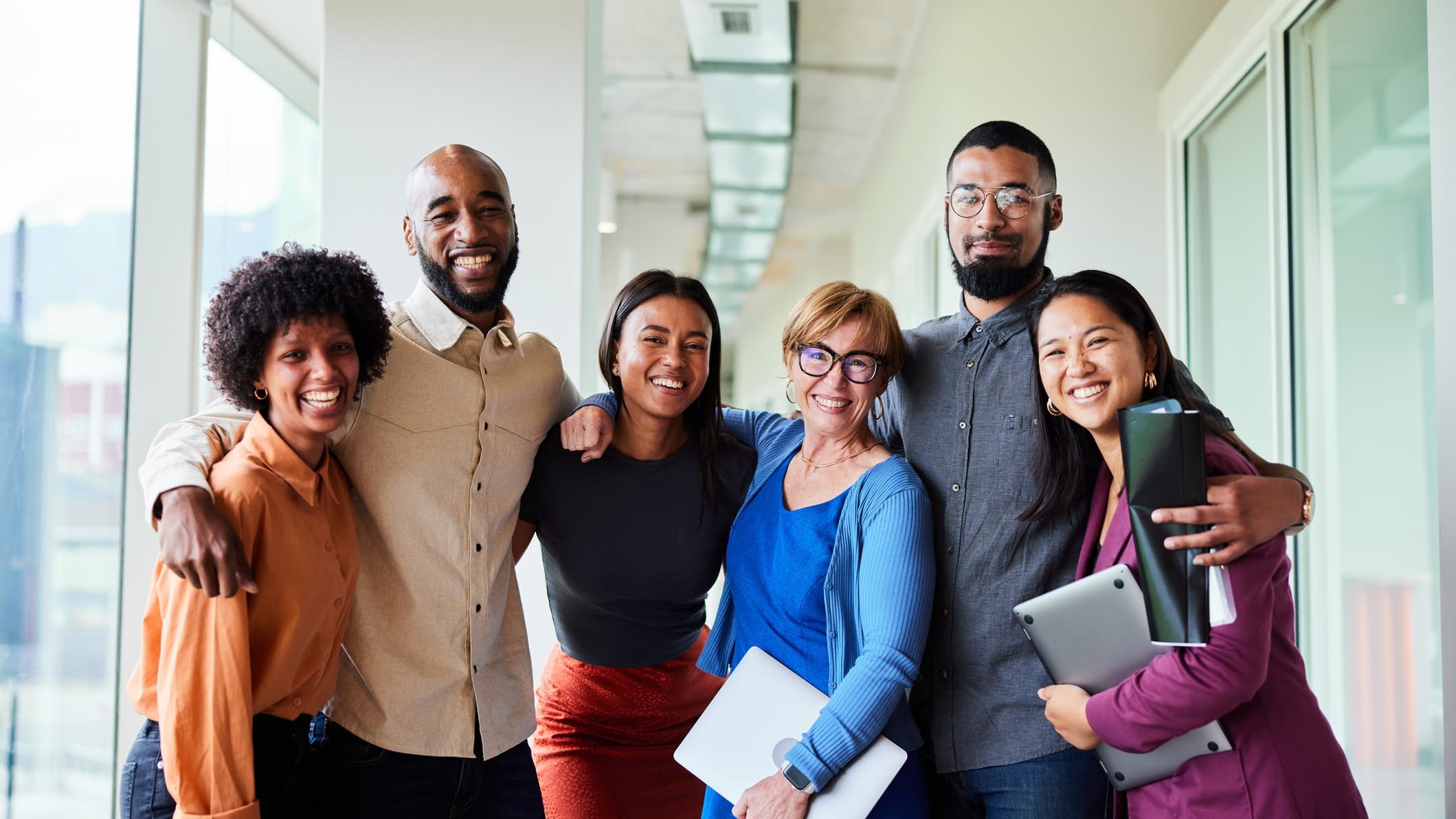 Coworkers standing together smiling Happy Employees