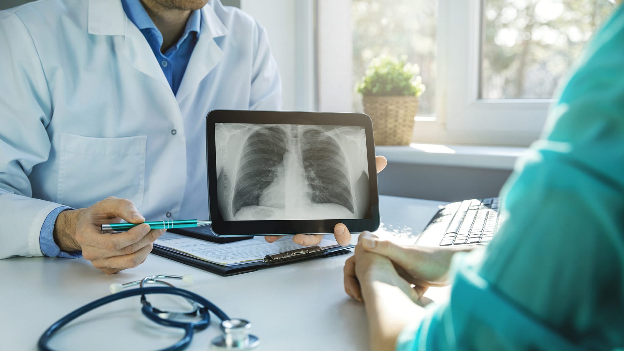 Close-up of doctor showing chest x-ray to patient.