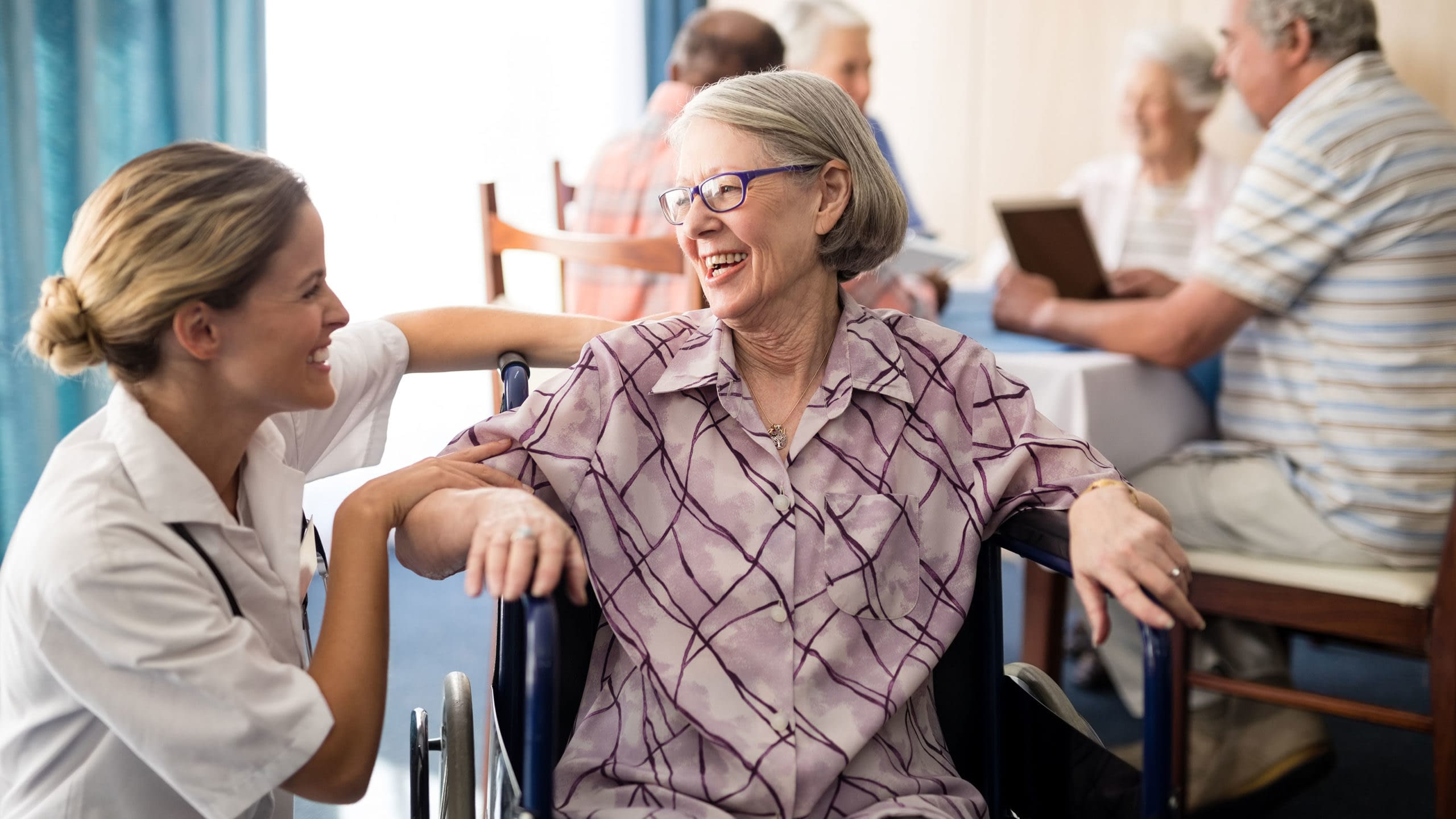Health care worker providing care to patient in a wheelchair.