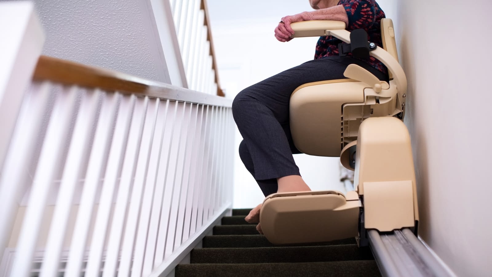 assistive devices elderly woman on stair lift