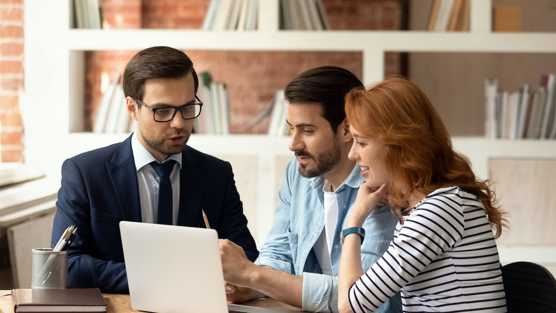 Young couple reviewing short-term health insurance plan with agent.