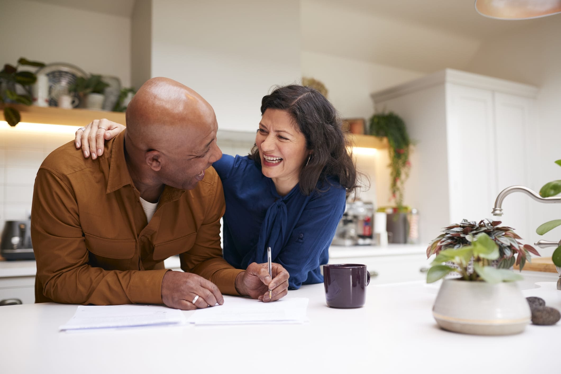 GettyImages-1282868177 Smiling Mature Couple Signing Paperwork