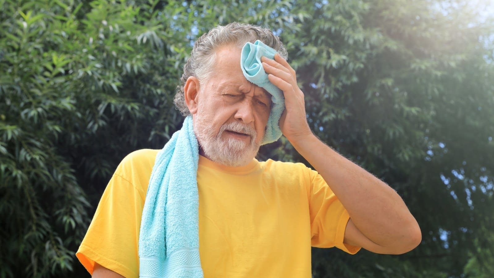 summer heat safety senior man wiping forehead from summer heat