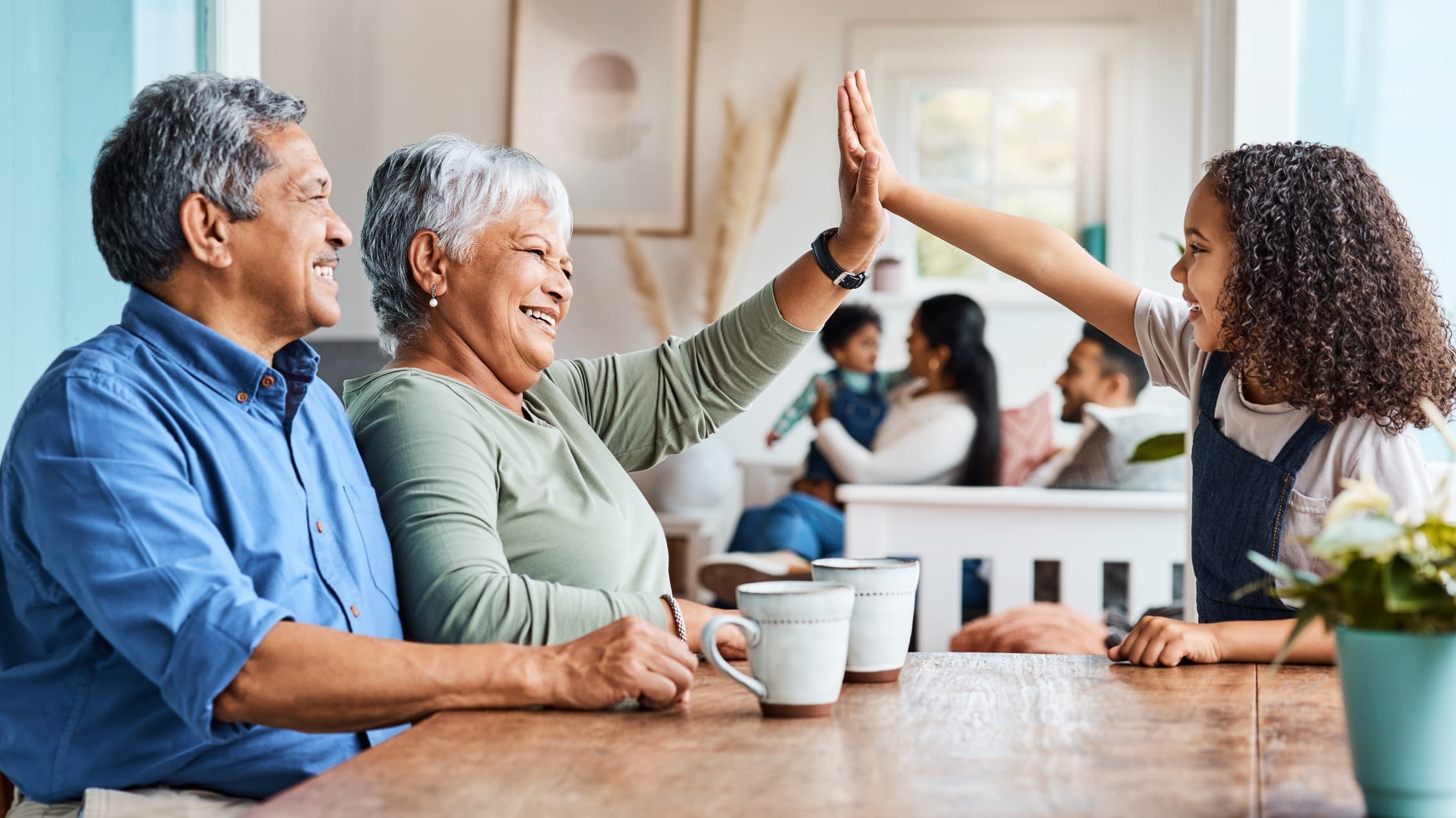 Grandmother giving granddaughter a high five Hispanic mature grandparents with granddaughter