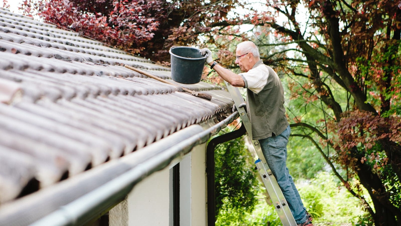 April 16 blog Older man cleaning rain gutters on his house