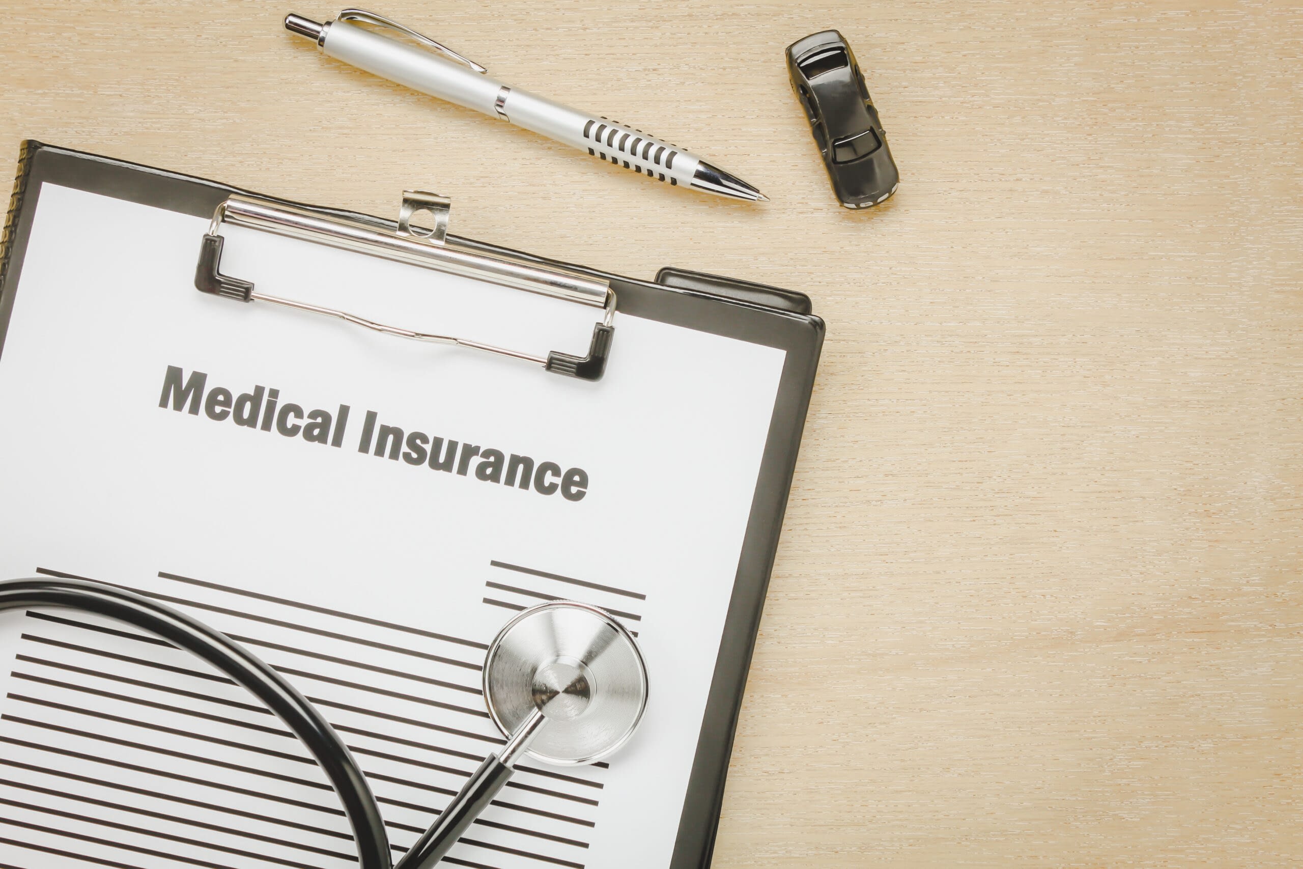 Top view medical insurance form with stethoscope,car on wooden b medicare