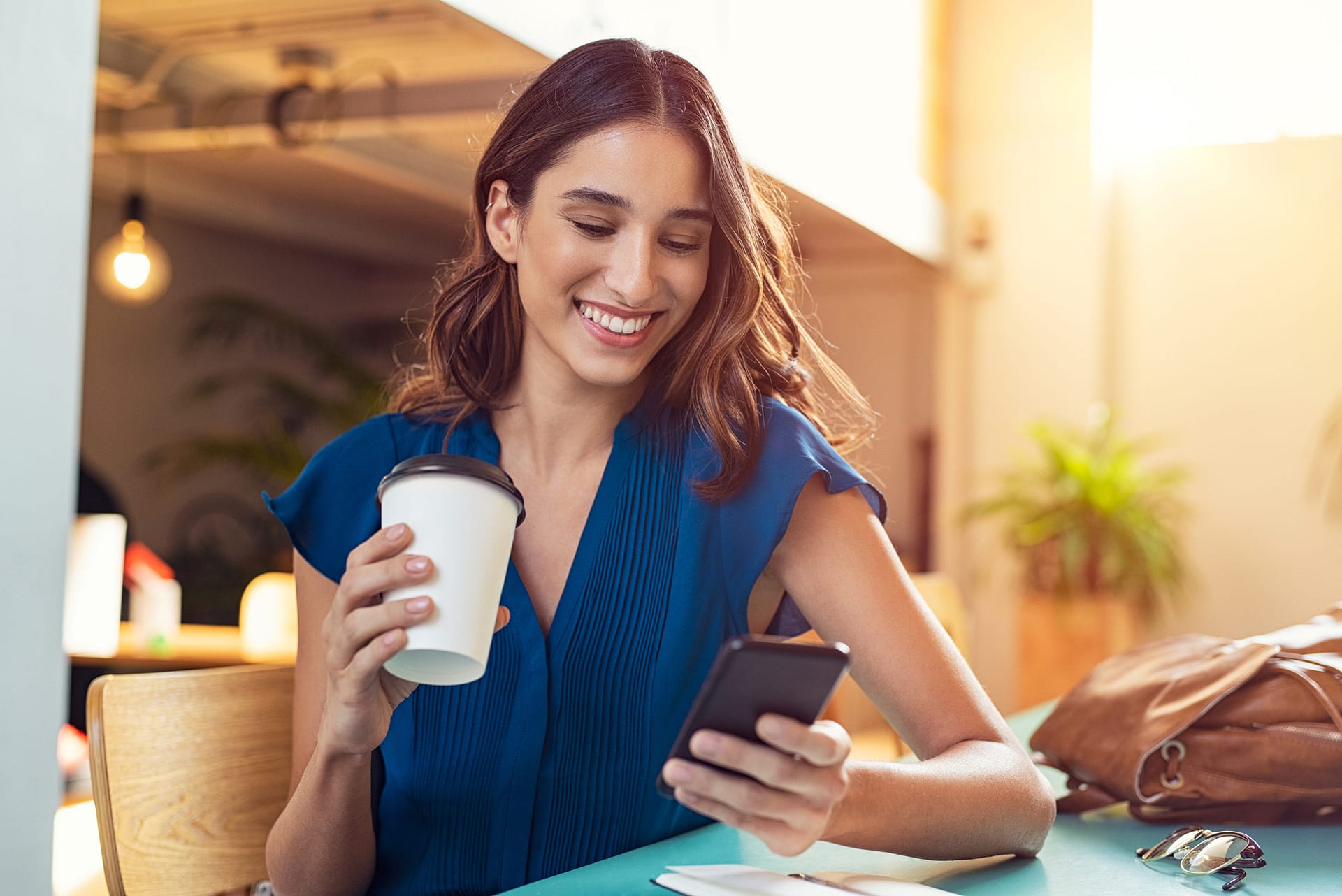 Woman-looking-at-phone-at-coffee-shop