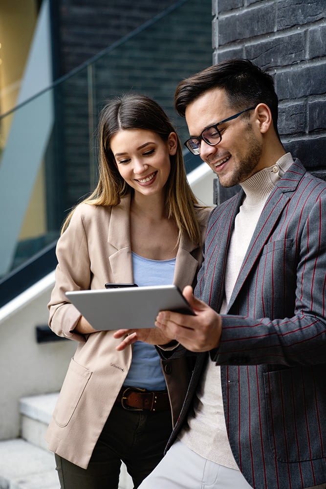 two-busniess-people-smiling-and-looking-at-tablet