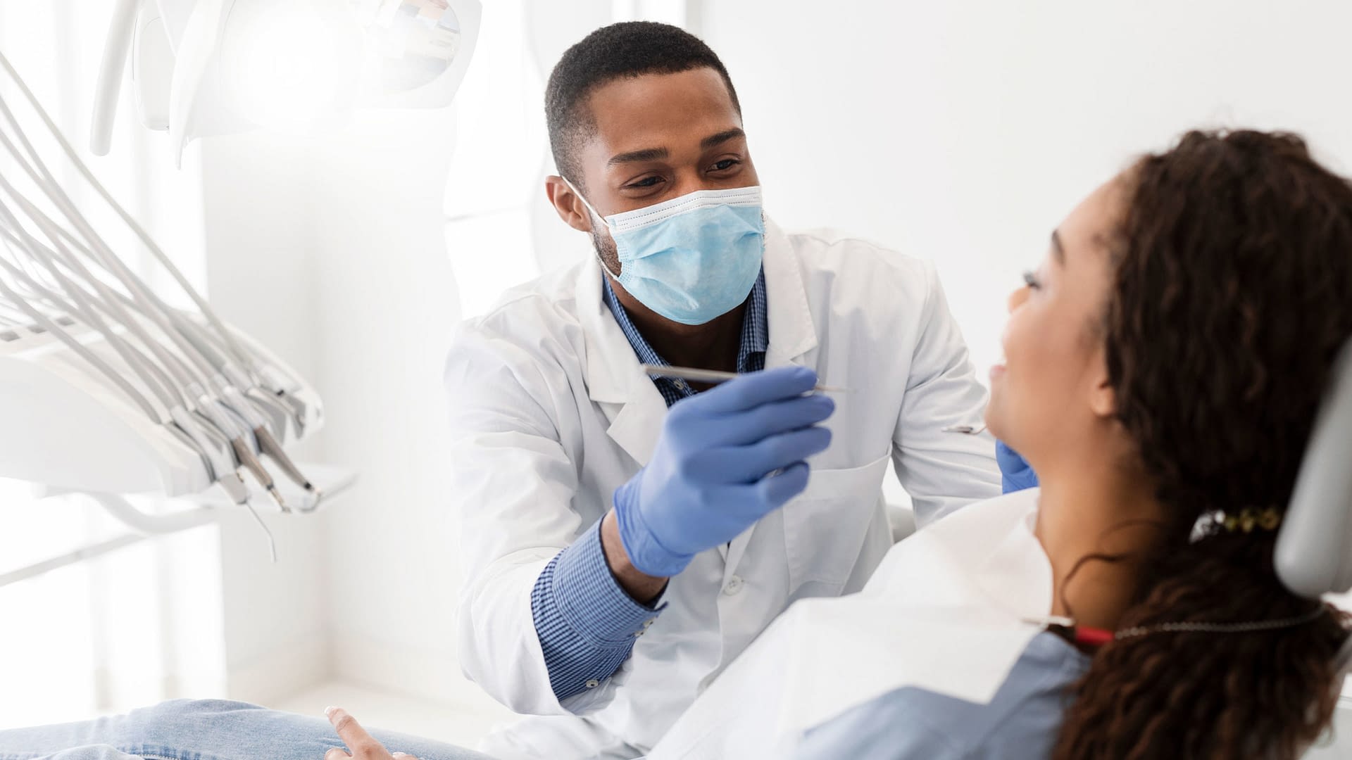 Friendly dentist working on patient's teeth.