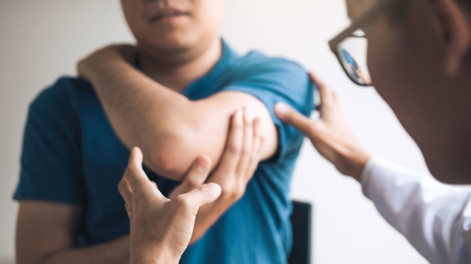 Doctor examining patient's injured elbow.