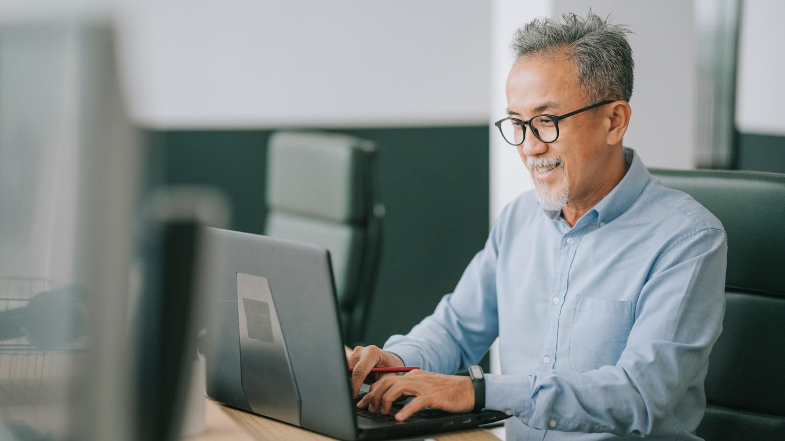 senior male in office working Asian man working on computer