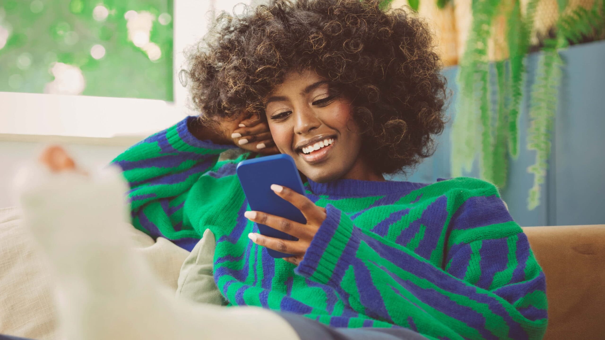 7-25 Blog Image young african american woman smiling looking at her phone