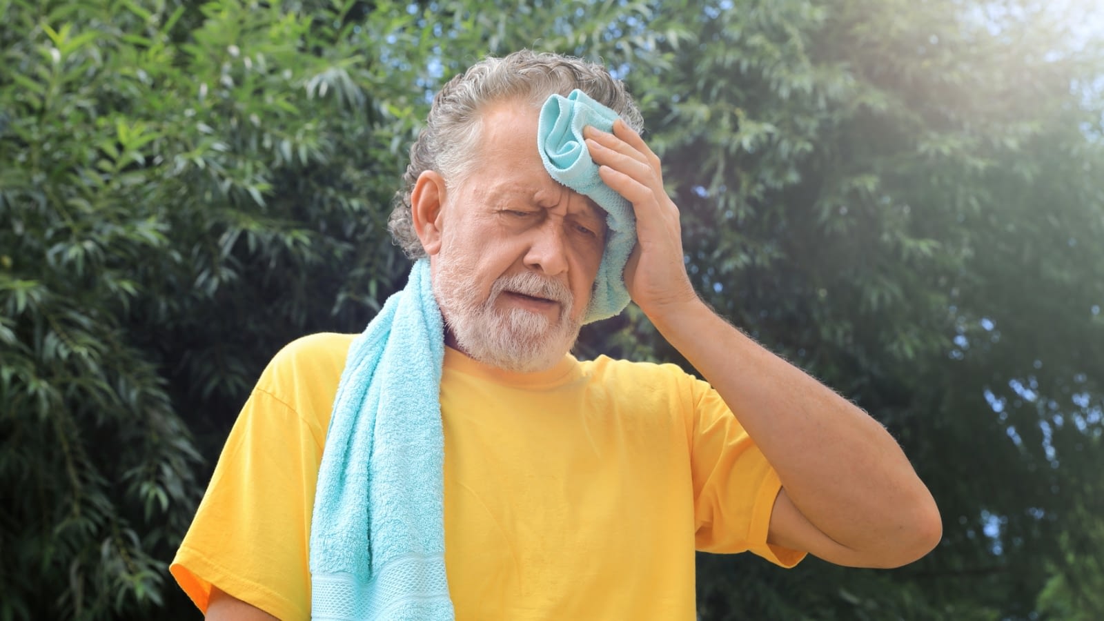 senior man wiping forehead from summer heat